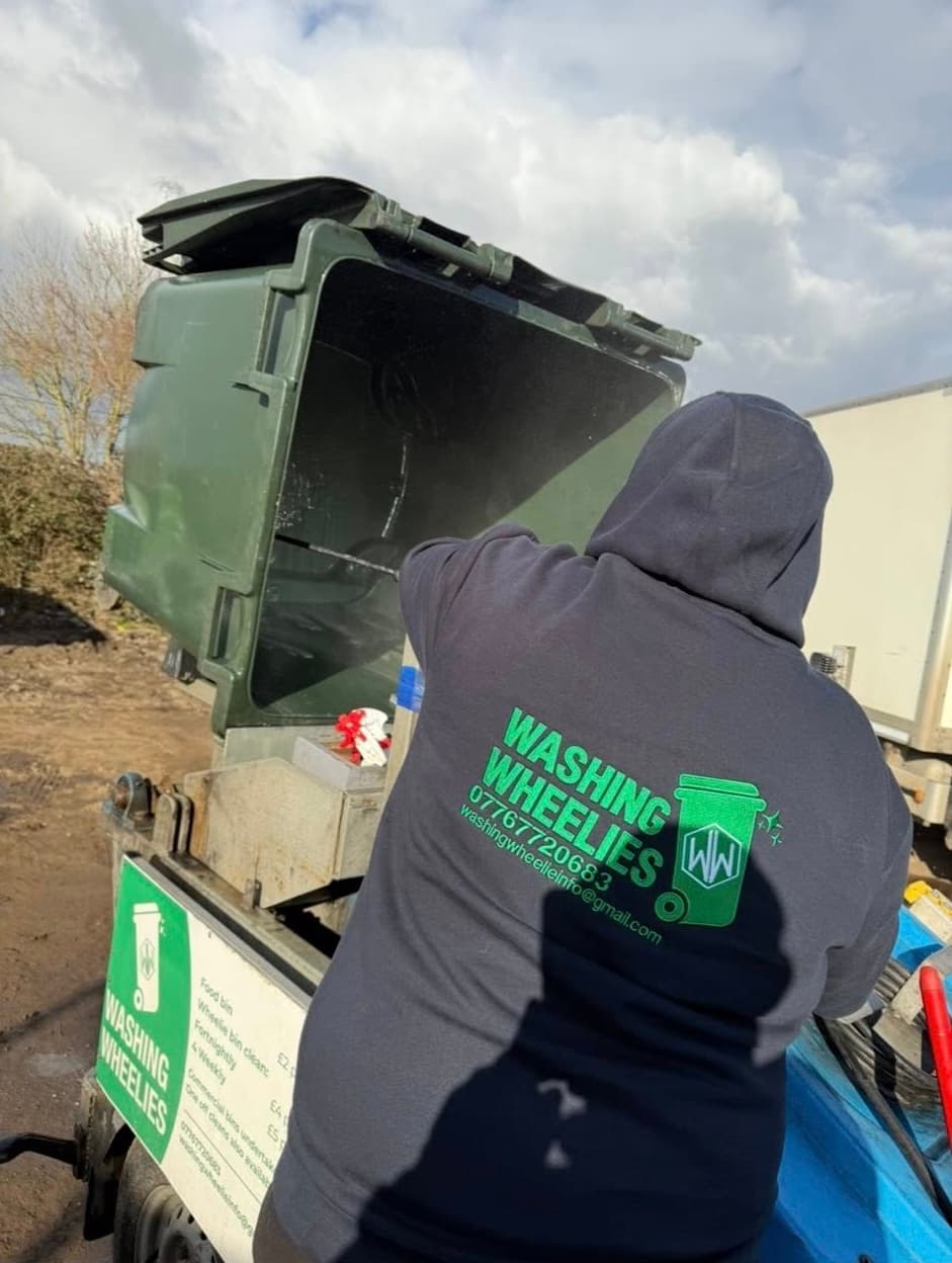 A Washing Wheelies operator tilting a wheelie bin onto the cleaning trailer